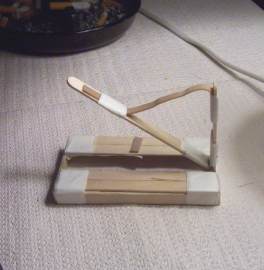 Tape the rubber band to the catapult arm