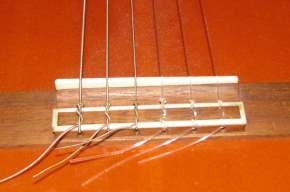 Nylon strings knotted onto the guitar