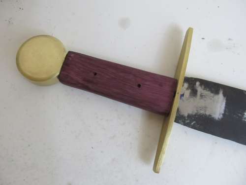 The brass pommel of the sword handle