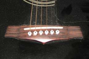 Steel strings pegged onto the guitar