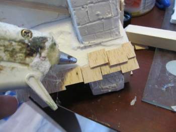 Glue down the roof shingles in a pattern